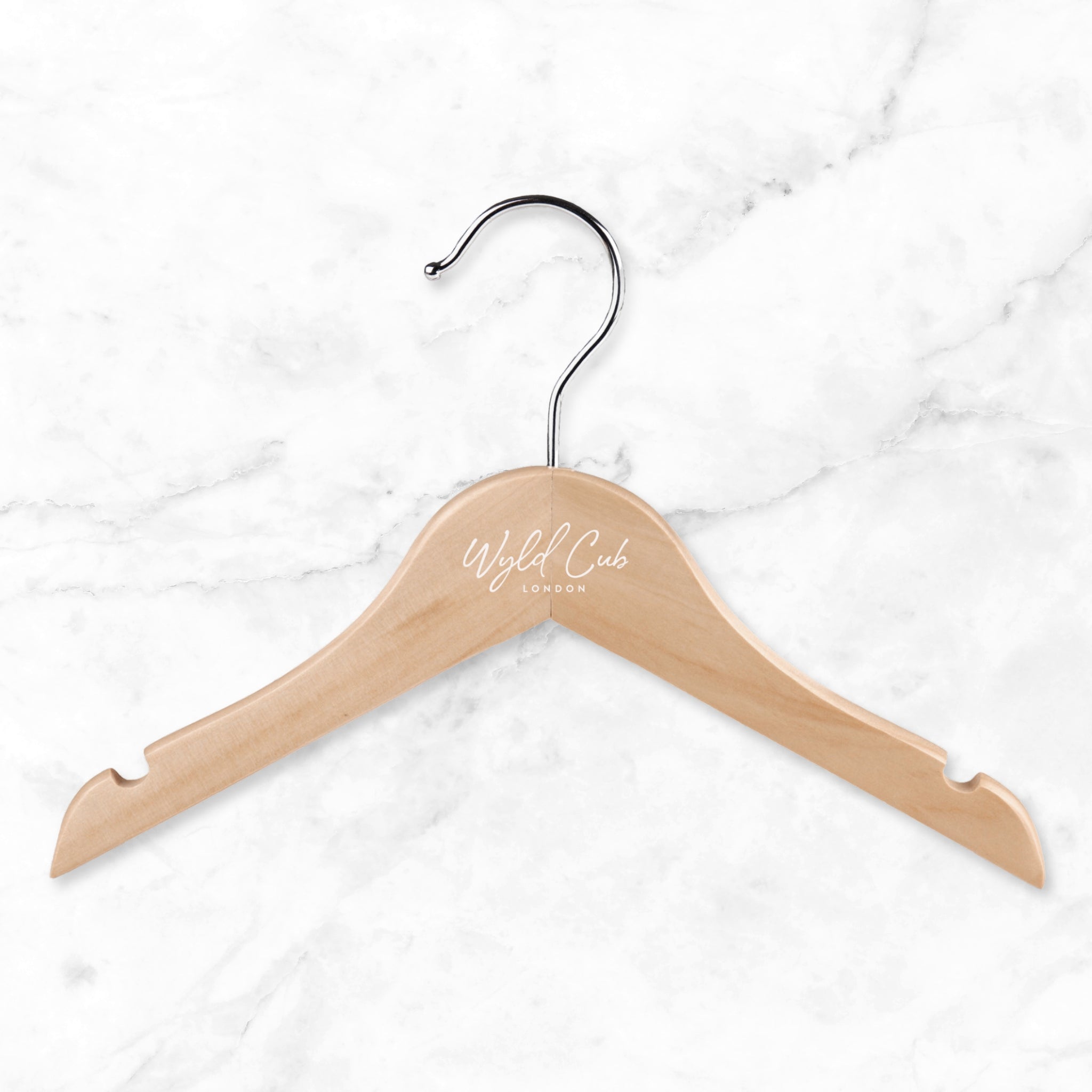 Wooden hanger with 'World Club London' branding on a white marble background